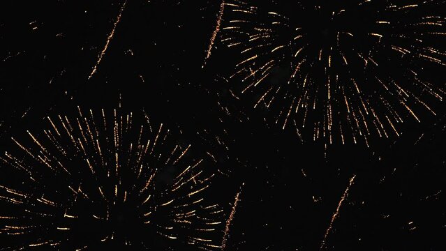 Golden glow of fireworks on the black night sky. Overall plan