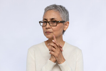 Portrait of doubtful senior woman wearing eyeglasses. Mature Caucasian woman wearing eyeglasses and...