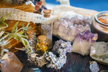 A very soft focus on a selection of minerals and traditional magical jewelry. Witch jewelry. Concept of a blurry background with candles and a wooden table. Blurred mystical background for Halloween