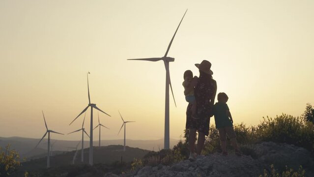 Mom shows the children how to generate electricity with windmills. Environmental protection and ecological wind energy. High quality 4k footage