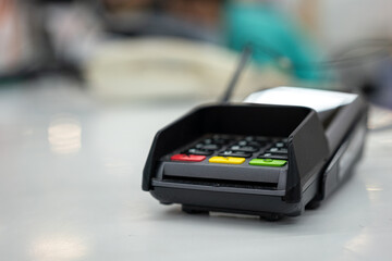 A credit card reader machine at the payment cashier. Financial technology device object photo. Close-up and selective focus at the card insert slot part.