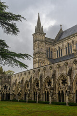 view of the spire and cloister of the Salisbury Cathedral on a rainy and overcast day