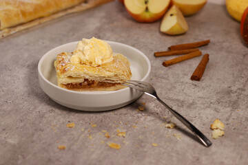 piece of an apple strudel roll with cinnamon and ice cream on top