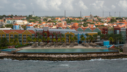 Willemstad, Curacao - 04.28.2021 View of colorful colonial buildings and pool near the sea in the old historical city center of the town Willemstad 