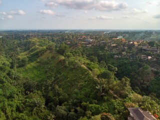 Fototapeta na wymiar Scenic view of houses in mountains covered in greenery in Indonesia, Bali