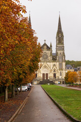 Fototapeta na wymiar Autumn leaves along the boulevard de la Basilique at Sanctuaire Notre-Dame de Montligeon