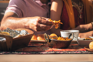 Close-up of Indian father's hand Picking up Indian food, which is to food culture of Indians, to Indian family and food concept.