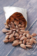 almond nuts spilling from a packet on table 
