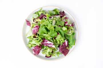 Green lettuce salad with fresh mixed vegetables isolated on white background. Top view, flat lay.	