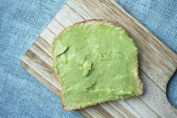 avocado spread on a bread on a chopping board 