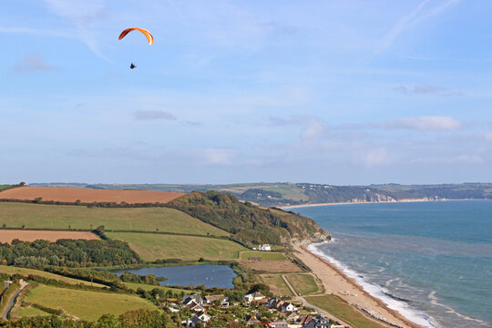 Paraglider flying above Beesands in Devon