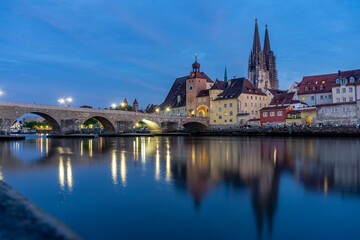 Fototapeta na wymiar Schöne Stadt Regensburg: Sonnenuntergang in der Innenstadt an der Donau mit Fluß und Steinerner Brücke im schönsten Abendlicht, Stimmung