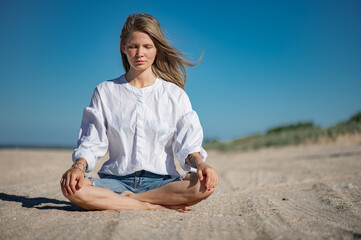 Fototapeta na wymiar Girl practice meditation on the beach. With space for text or design