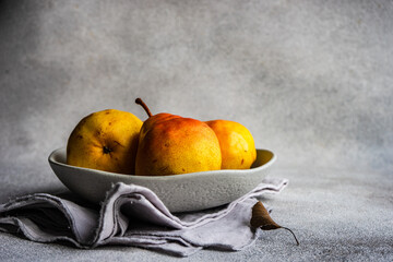 Close-Up of a bowl of pears on a table with a napkin