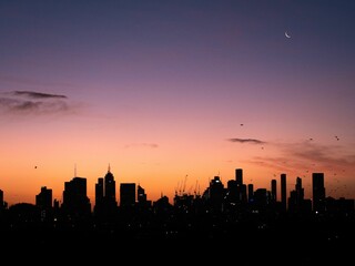 Fototapeta na wymiar Silhouette of skyline against an orange sunset sky