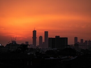 Fototapeta na wymiar Silhouette of skyline against an orange sunset sky
