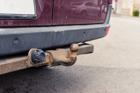Close up to a rusty tow bar or hitch at the rear of an old with ball mount