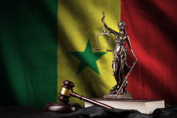 Senegal flag with statue of lady justice, constitution and judge hammer on black drapery. Concept...