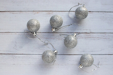 Christmas ornaments on white wooden background Christmas decorations silver balls on white table. Top view, flat lay, copy space. Winter holiday preparation