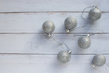 Christmas ornaments on white wooden background Christmas decorations silver balls on white table. Top view, flat lay, copy space. Winter holiday preparation