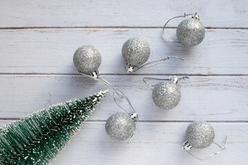 Christmas ornaments on white wooden background Christmas decorations silver balls and Christmas tree on white table. Top view, flat lay, copy space. Winter holiday preparation