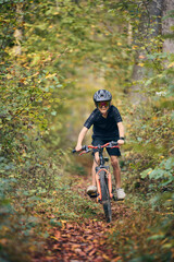 Enfant en vélo dans les bois en automne