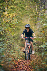 Enfant en v&eacute;lo dans les bois en automne