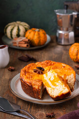 Round cottage cheese casserole with pumpkin layer on a ceramic plate on a brown wooden background. Pumpkin recipes. Thanksgiving, Halloween