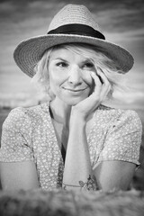 Monochrome portrait of a pretty lady in summer apparel posing on harvested cornfield