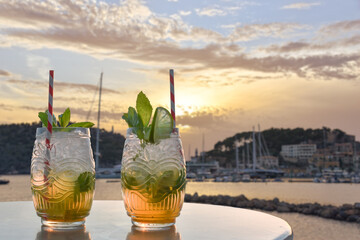 two drinks in front of a mediterranean harbor - obrazy, fototapety, plakaty