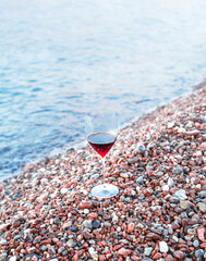 One glass with red wine on the shores of the Adriatic Sea in Montenegro