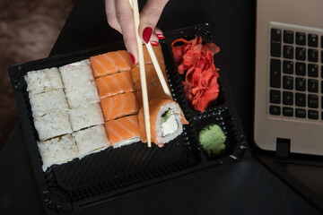 Woman's hand holding sushi chopsticks