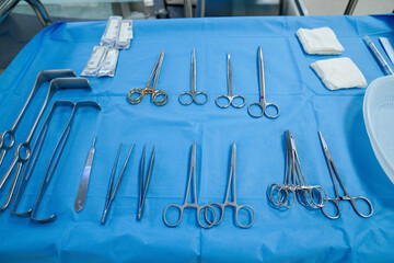 surgical instruments and tools including scalpels, forceps and tweezers arranged on a table for a...