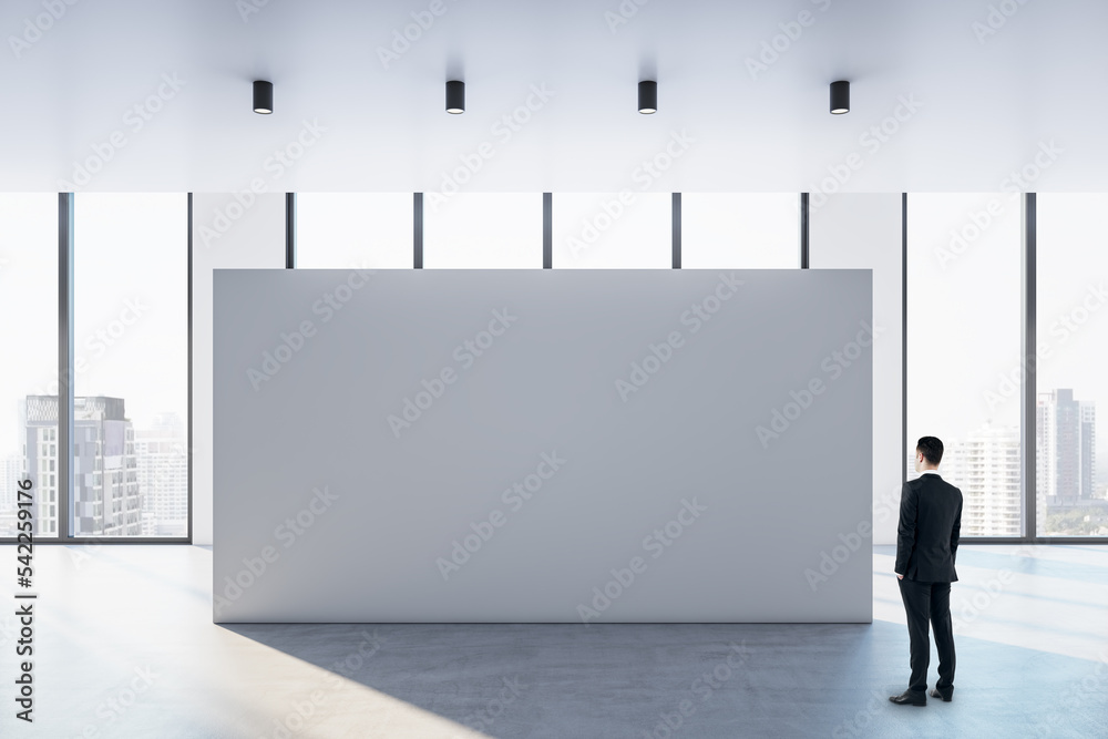Poster businessman perspective view looking at big blank white partition with place for advertisement or po