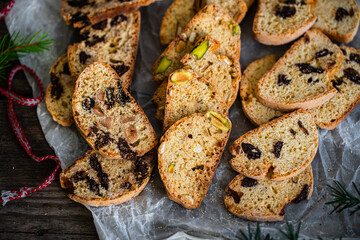 Christmas cookies. Heap of three different kinds of biscotti (chocolate, dried fruits, pistachio) on wooden table.