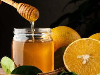 Miel de abeja con naranjas y canela en una tabla de madera.