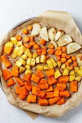 Oven-baked vegetables on a baking sheet. Baked pumpkin, potatoes, carrots and onions. Cooking dinner in the oven. Vegetarian food in the oven. Vegan cuisine. Proper and healthy nutrition