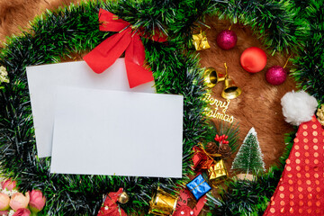 Fototapeta na wymiar White Blank Christmas Greeting Card Encircled by Christmas Decorations