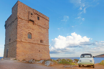 Salento typical landscape with coastal tower and old italian vintage cult car, Apulia, Italy