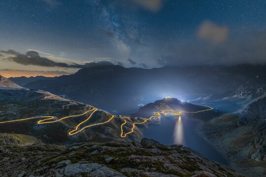 Mystic view of a lake and mountains on a starry night in the Gran Paradiso, Colle del Nivolet, Italy