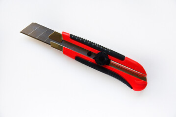 Red stationery knife with blades on a white background. Cutting tool with blades on a white background.