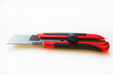 Red stationery knife with blades on a white background. Cutting tool with blades on a white background.