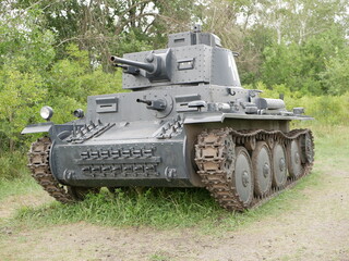 Fototapeta premium Czechoslovak light tank of the Second World War, which was in service with the Wehrmacht. A tank painted dark gray on a forest road.