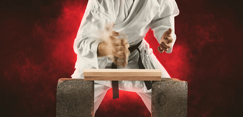Karate master breaks a wooden board with his hand