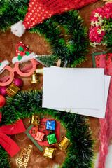 Fototapeta na wymiar White Blank Christmas Greeting Card Encircled by Christmas Decorations