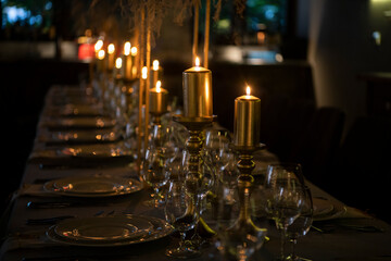 Fototapeta na wymiar Luxury elegant table setting dinner with candles and light bulbs in a restaurant