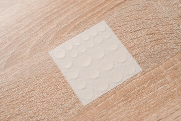 Fototapeta na wymiar Set of round patches for acne on wooden background. Acne patches for the treatment of pimple and rosacea close-up. Facial rejuvenation cleansing cosmetology.