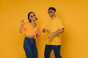 Young beautiful smiling happy couple in sun glasses dancing