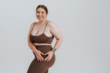 European woman smiling and showing heart gesture