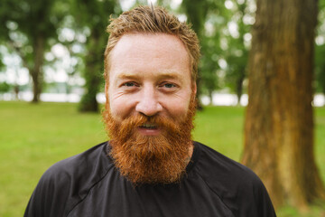 Fototapeta premium Portrait of young handsome bearded redhead smiling man